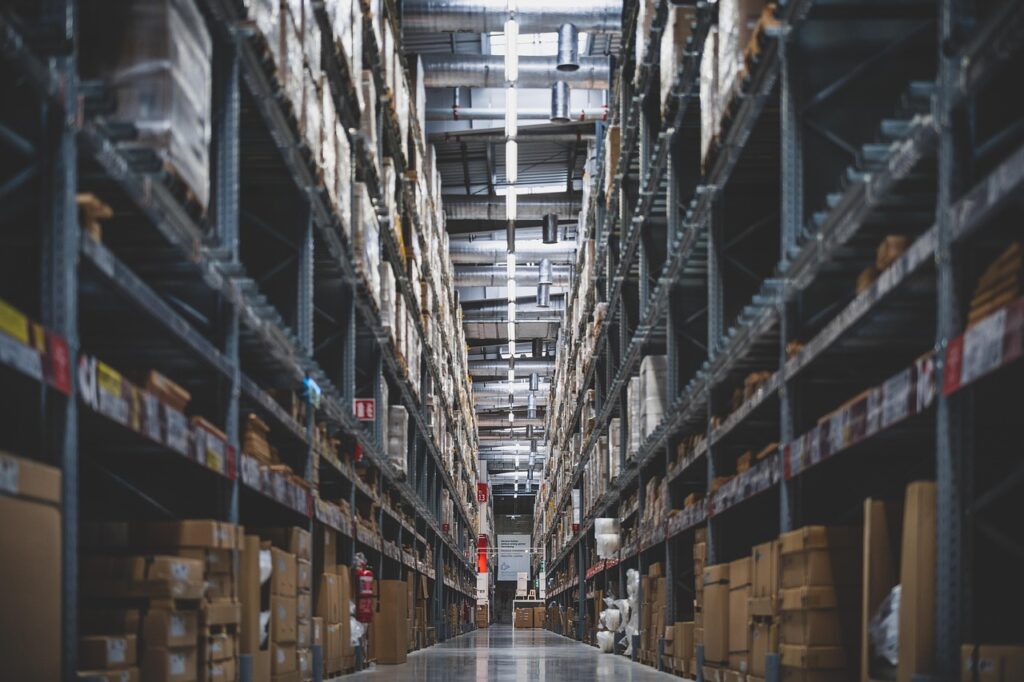 Long warehouse aisle lined with tall shelves of boxed stock