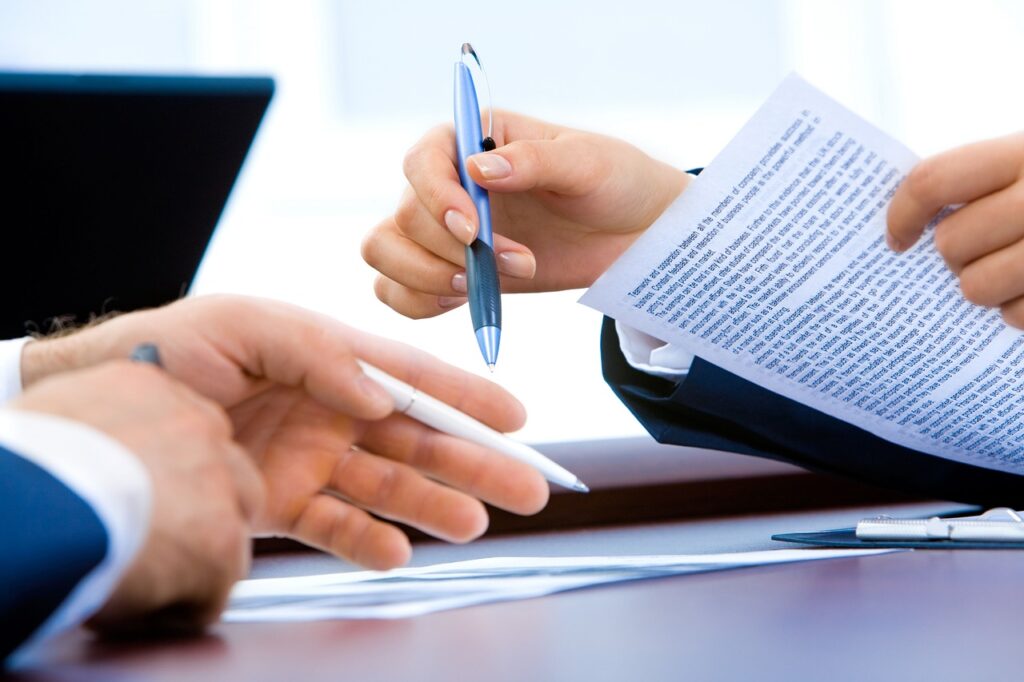 Two people reviewing a printed document with a pen