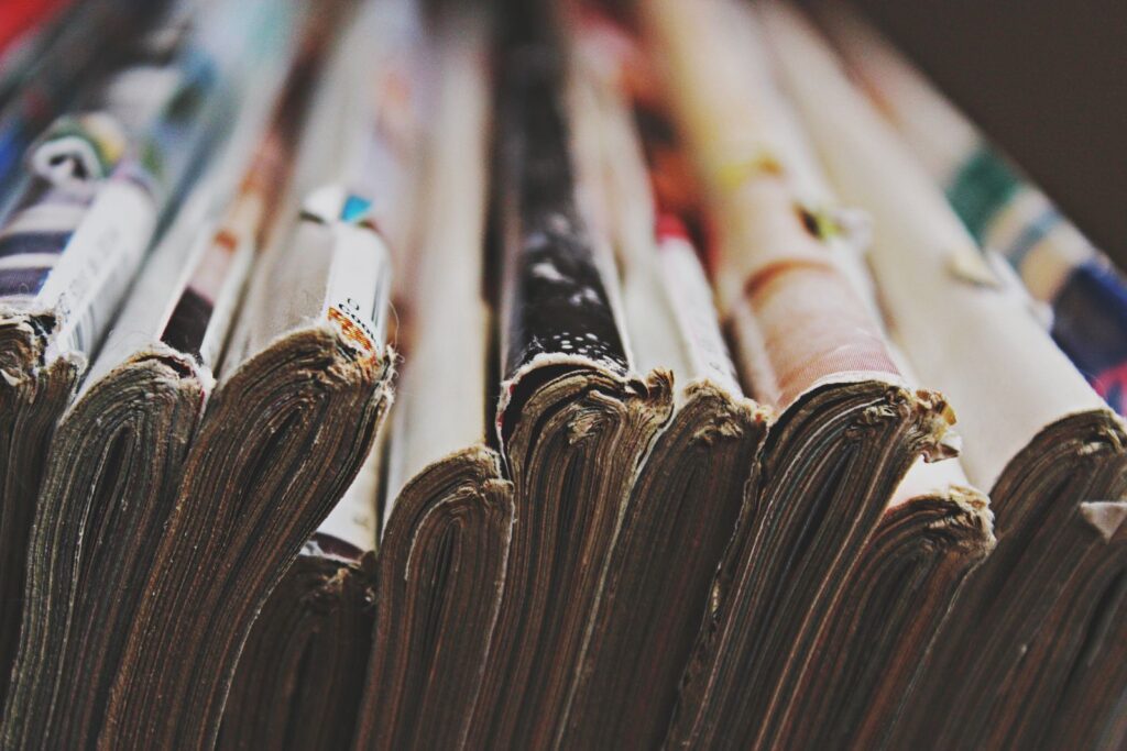 Close view of the stacked spines of many magazines